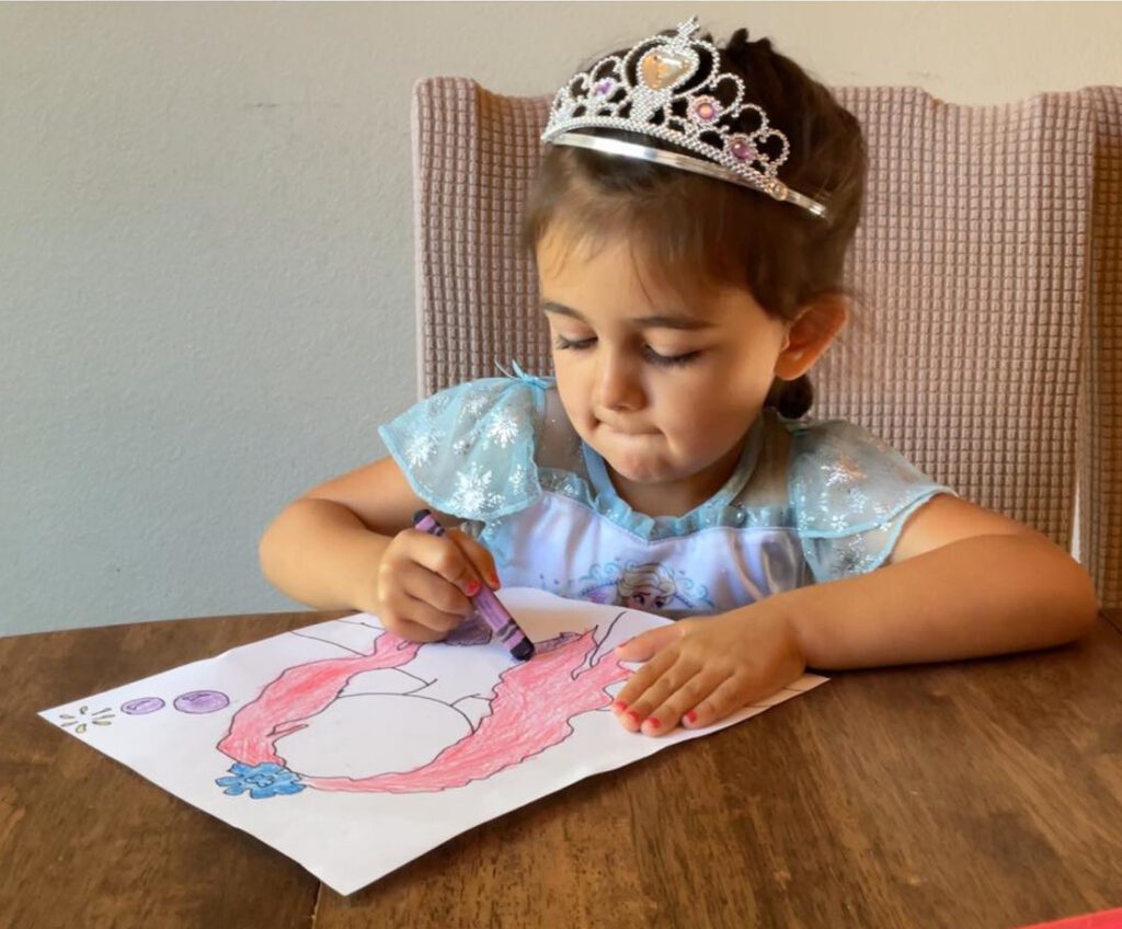 Madison is five and concentrating intently on coloring her page just right.